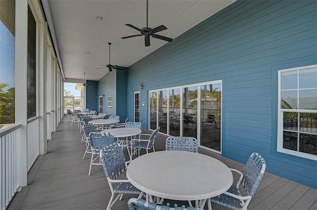 deck with outdoor dining space and ceiling fan