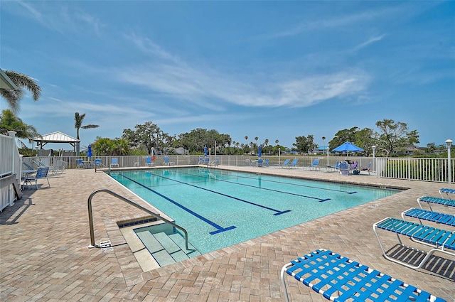 community pool featuring fence and a patio area