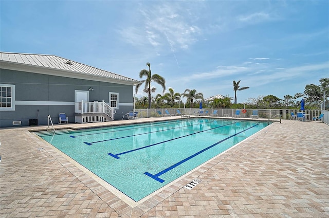 community pool featuring fence and a patio