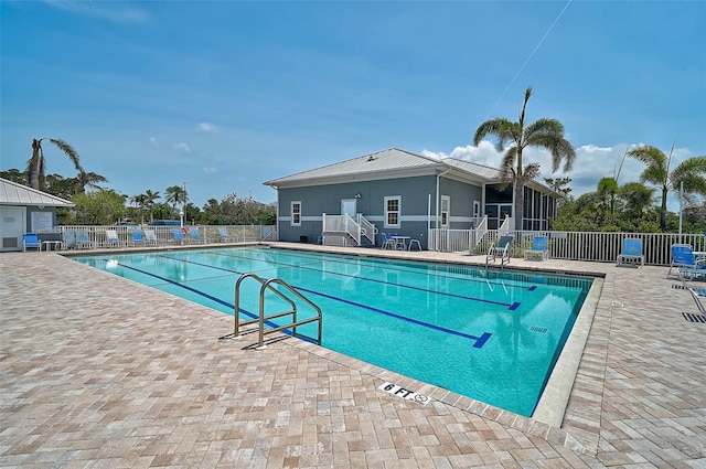 community pool with fence and a patio