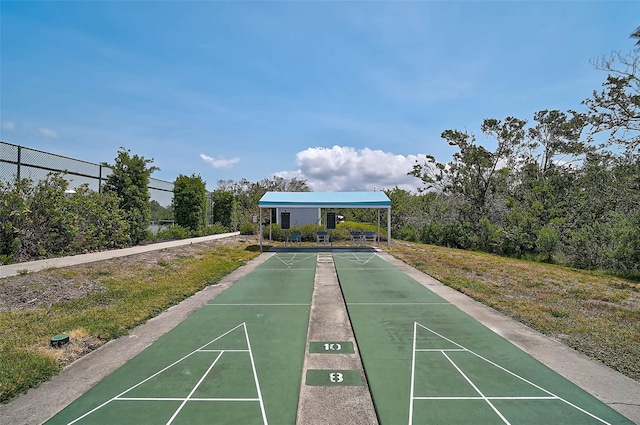 view of community with shuffleboard and fence