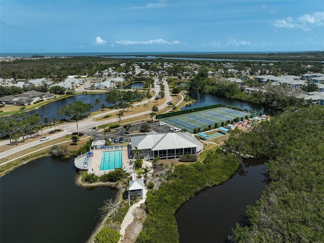 aerial perspective of suburban area featuring a nearby body of water and a pool area