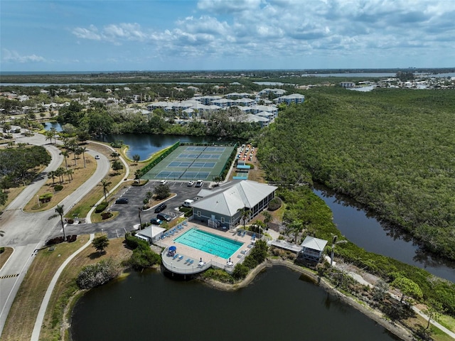 aerial view of property and surrounding area featuring a pool area and a nearby body of water