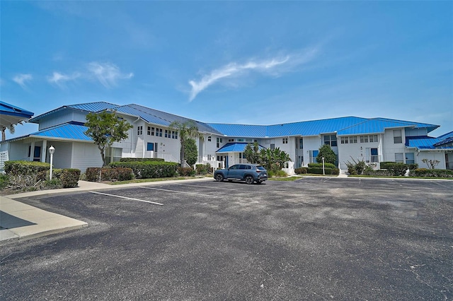 view of building exterior with uncovered parking and a residential view