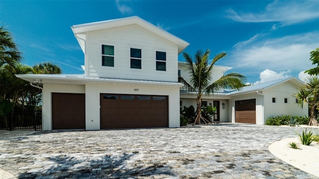 603 Emerald Ln, Holmes Beach, FL 34217 - view of front facade featuring stucco siding, decorative driveway, and a garage