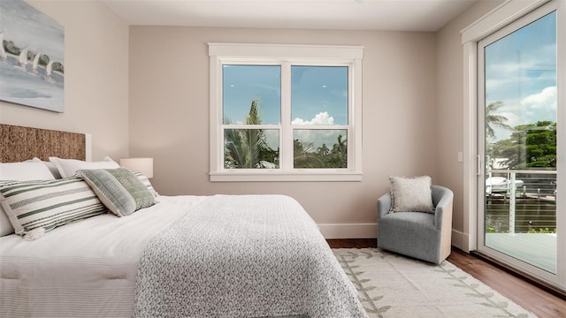 603 Emerald Ln, Holmes Beach, FL 34217 - bedroom featuring access to outside, multiple windows, and wood finished floors