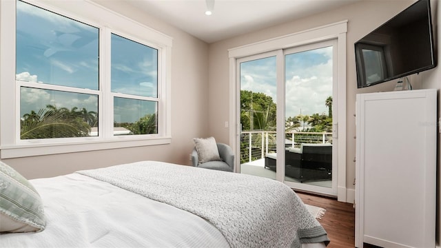 603 Emerald Ln, Holmes Beach, FL 34217 - bedroom with access to exterior and dark wood-style floors