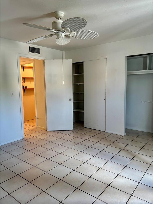 unfurnished bedroom featuring two closets and a ceiling fan