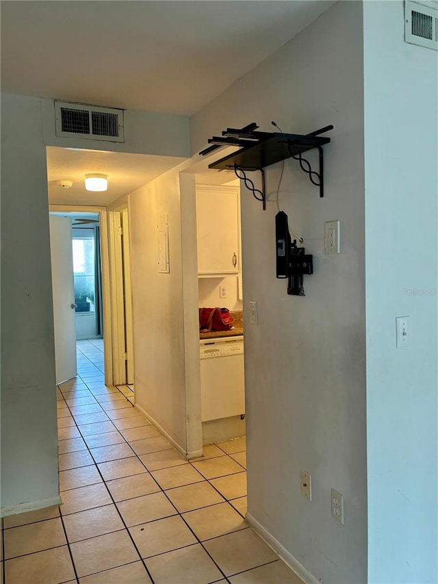 corridor featuring light tile patterned floors and baseboards
