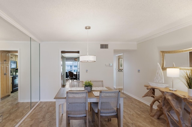 dining room featuring ornamental molding, baseboards, and a textured ceiling