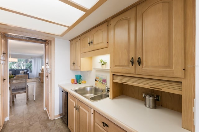 kitchen with a sink, light brown cabinetry, black dishwasher, and light countertops