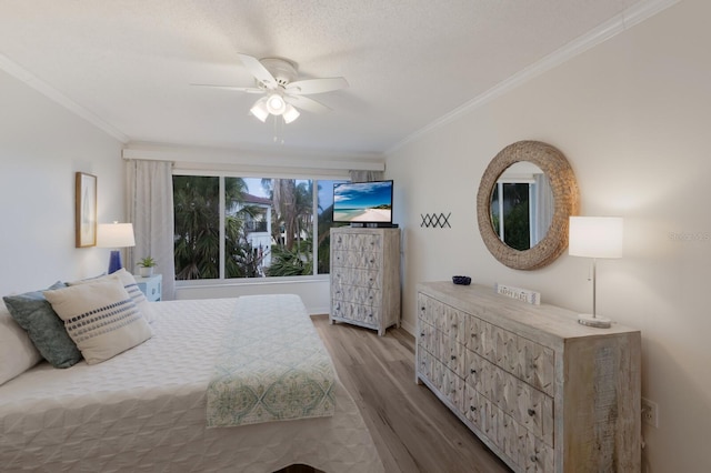 bedroom with wood finished floors, crown molding, a ceiling fan, and baseboards