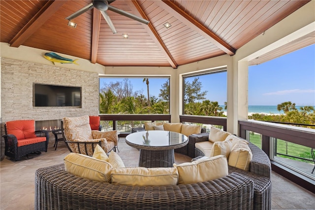 sunroom / solarium with wood ceiling, a water view, and stone finish flooring