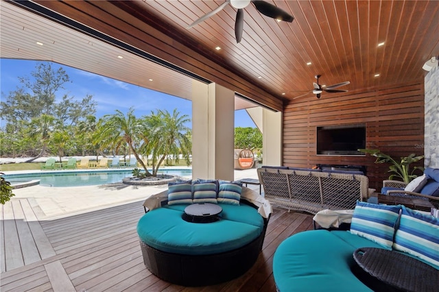 wooden deck with a ceiling fan, outdoor lounge area, and an outdoor pool