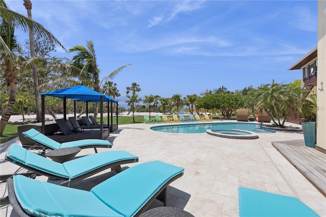 view of swimming pool with a patio area and a pool with connected hot tub
