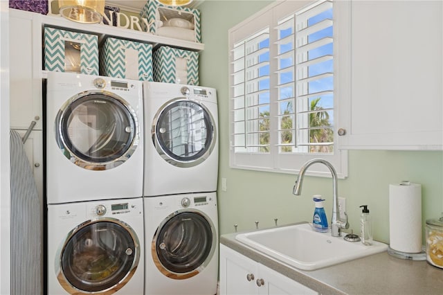 laundry area with stacked washer and clothes dryer, cabinet space, and washing machine and clothes dryer