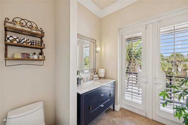 half bathroom featuring plenty of natural light, crown molding, toilet, vanity, and baseboards