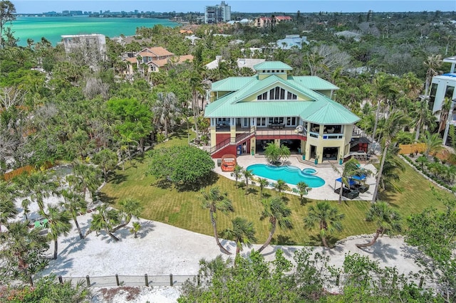 aerial view of property and surrounding area featuring a pool and a nearby body of water
