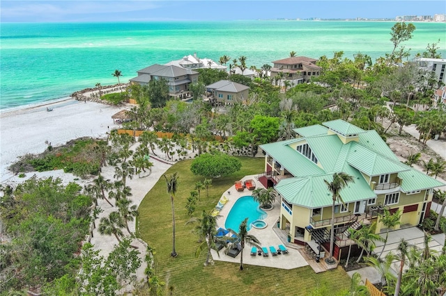 drone / aerial view of a nearby body of water and a pool area