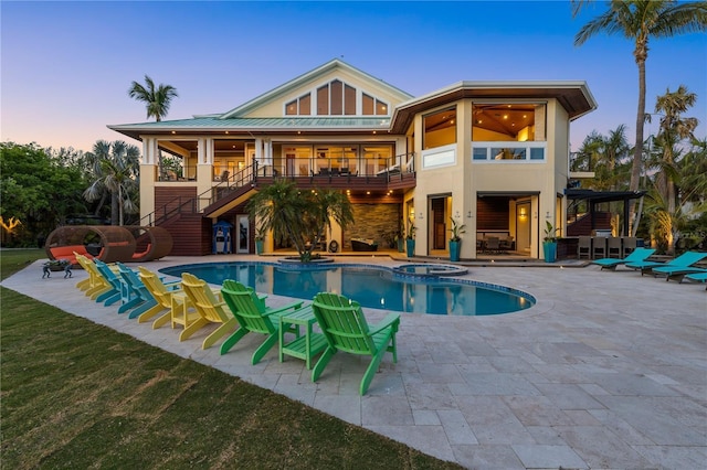 rear view of property with stairs, a patio area, a balcony, a yard, and metal roof