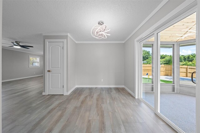 219 Vermont Ave, Saint Cloud, FL 34769 - unfurnished dining area with wood finished floors, crown molding, a chandelier, a textured ceiling, and baseboards