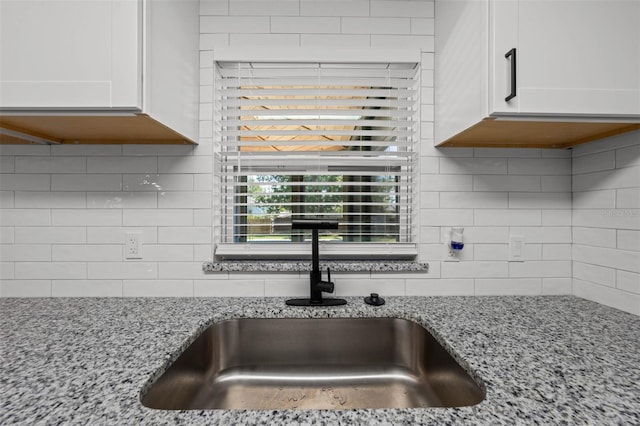 219 Vermont Ave, Saint Cloud, FL 34769 - kitchen view of a sink, tasteful backsplash, white cabinetry, and light stone counters