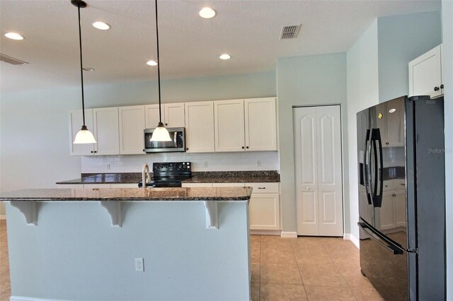 7311 64th St E, Palmetto, FL 34221 - kitchen with black appliances, a breakfast bar, backsplash, white cabinets, and dark stone countertops