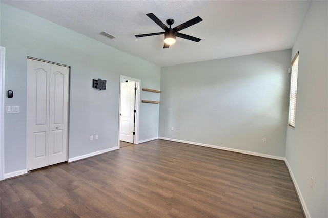 7311 64th St E, Palmetto, FL 34221 - unfurnished bedroom with dark wood finished floors, baseboards, and ceiling fan