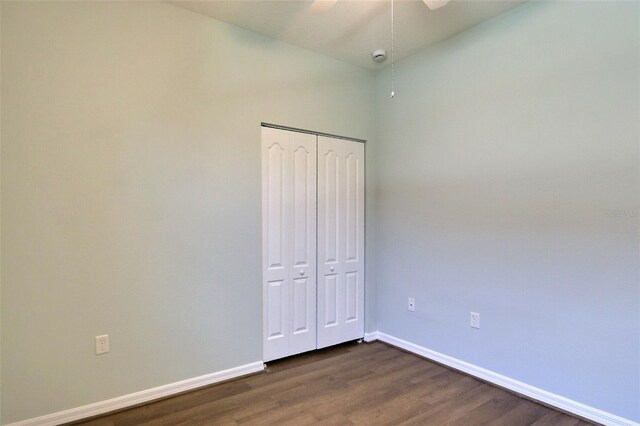 7311 64th St E, Palmetto, FL 34221 - unfurnished bedroom with baseboards, dark wood-type flooring, a closet, and ceiling fan