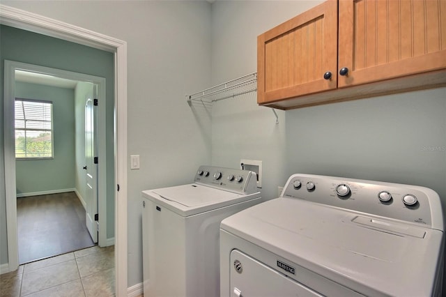 7311 64th St E, Palmetto, FL 34221 - washroom featuring washing machine and clothes dryer, light tile patterned floors, baseboards, and cabinet space