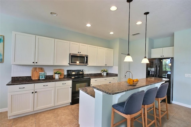 7311 64th St E, Palmetto, FL 34221 - kitchen with black appliances, a kitchen island with sink, light tile patterned floors, a kitchen bar, and pendant lighting