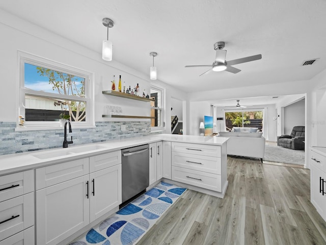 kitchen with dishwasher, a sink, ceiling fan, light wood-style flooring, and open floor plan