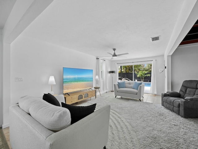 living area with ceiling fan and baseboards