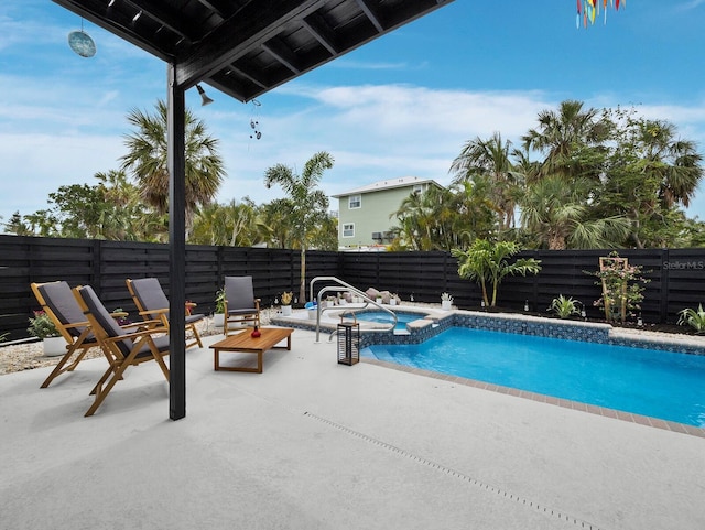 view of swimming pool with a patio, a fenced backyard, and a pool with connected hot tub