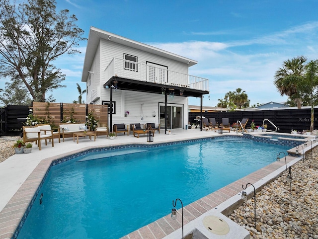 rear view of property featuring a fenced backyard, a balcony, an outdoor hangout area, and a patio area