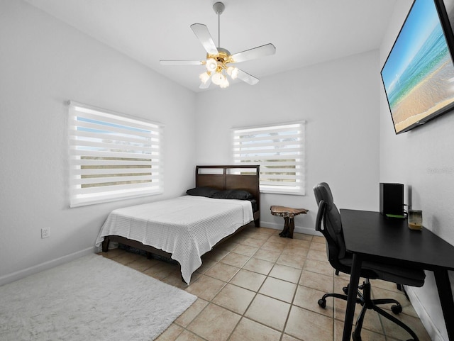 bedroom with a desk, light tile patterned flooring, baseboards, and ceiling fan