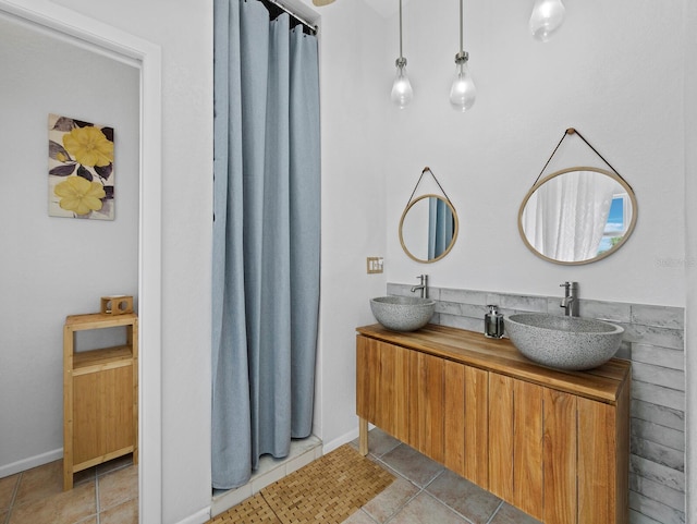 full bathroom featuring double vanity, tile patterned flooring, and baseboards