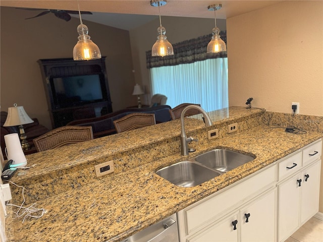 40 Mariner Ln, Rotonda West, FL 33947 - kitchen featuring a sink, light stone counters, white cabinets, hanging light fixtures, and lofted ceiling