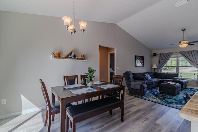 9085 SW 202nd Avenue Rd, Dunnellon, FL 34431 - dining room with vaulted ceiling, light wood finished floors, a chandelier, ceiling fan, and baseboards
