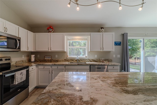 9085 SW 202nd Avenue Rd, Dunnellon, FL 34431 - kitchen featuring stainless steel appliances, a sink, light stone countertops, and white cabinets