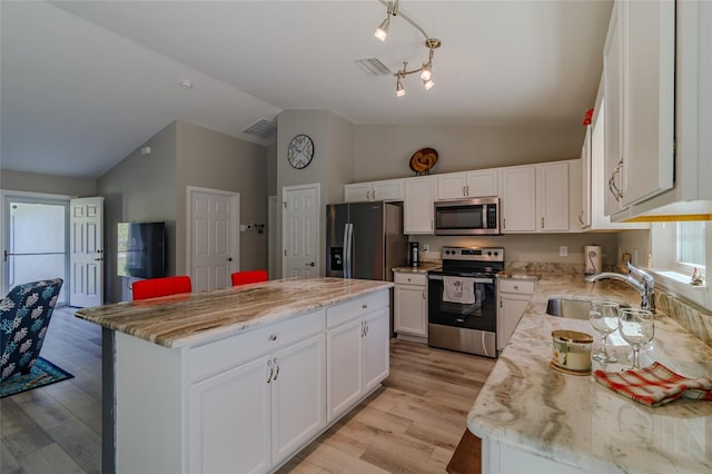 9085 SW 202nd Avenue Rd, Dunnellon, FL 34431 - kitchen with appliances with stainless steel finishes, a sink, lofted ceiling, a center island, and white cabinetry