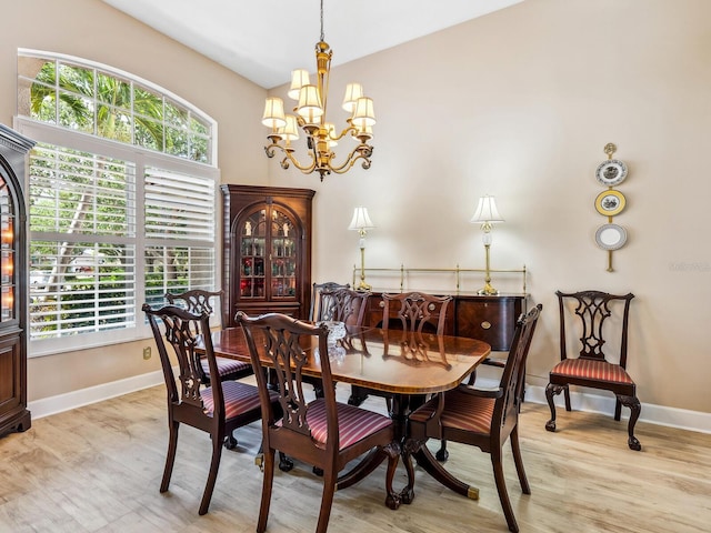 dining area featuring a chandelier, baseboards, and wood finished floors