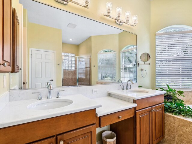 full bath with a stall shower, healthy amount of natural light, vanity, and tile patterned flooring