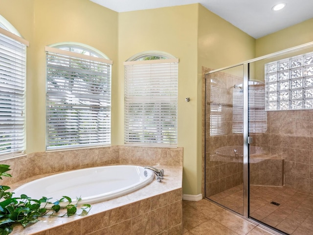 full bathroom with plenty of natural light, a stall shower, and a bath
