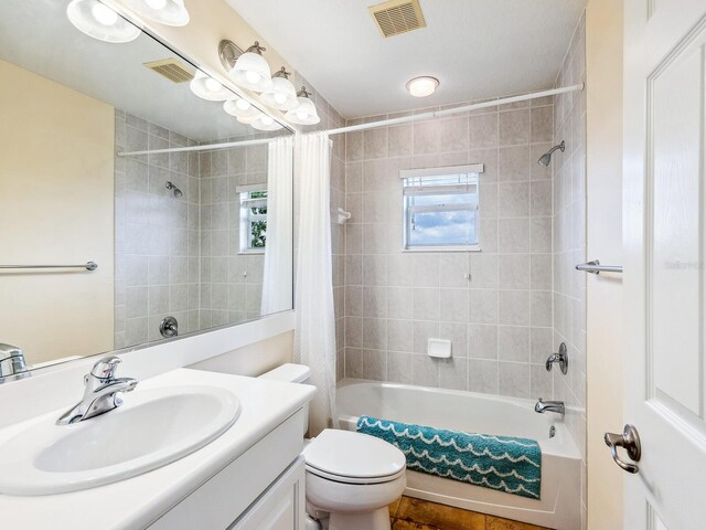 bathroom featuring shower / bath combo, toilet, and vanity