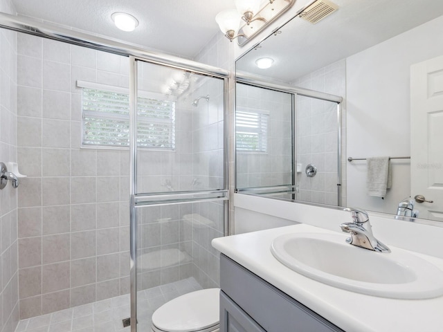bathroom featuring a stall shower, vanity, and toilet