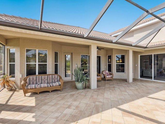 back of property featuring a patio, stucco siding, and glass enclosure