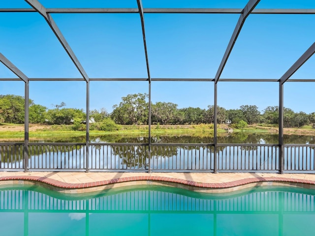 outdoor pool with a water view and view of scattered trees