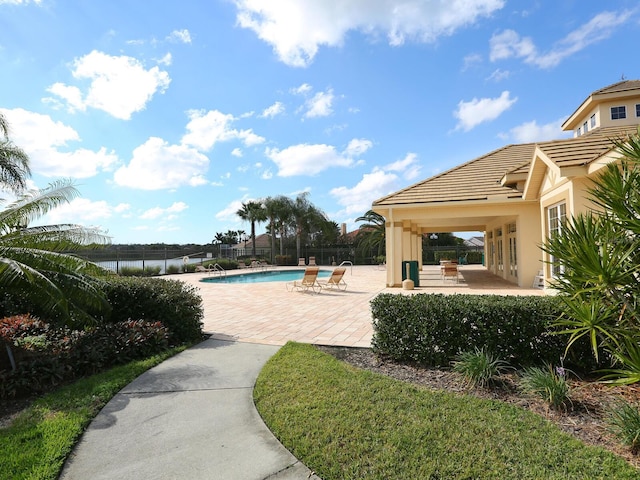 community pool with a patio and fence