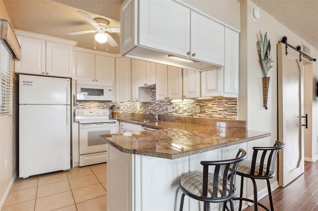 7193 W Country Club Dr N Unit 137, Sarasota, FL 34243 - kitchen with white appliances, a textured ceiling, ceiling fan, tasteful backsplash, and a peninsula